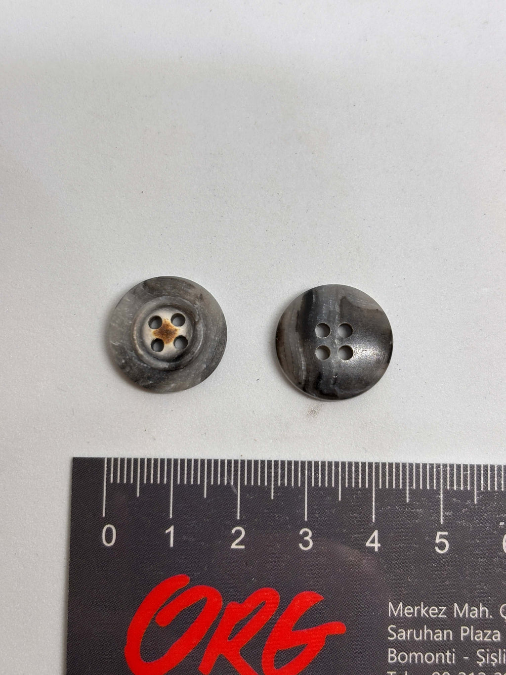 Botón 340MP Gris 4 Agujeros Plano 20mm con textura marmoleada tipo cuerno y detalle central de estrella oxidada. button