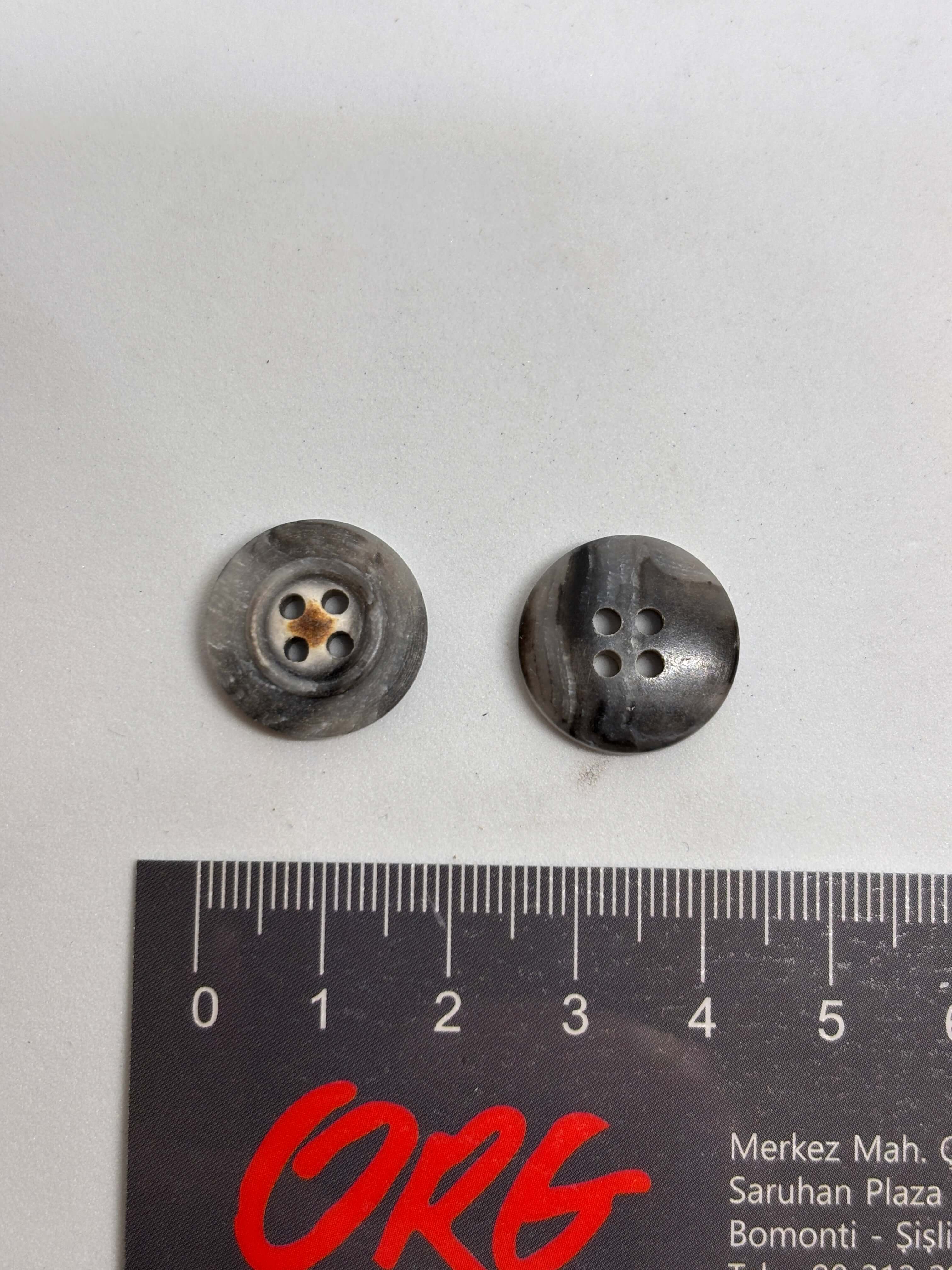 Botón 340MP Gris 4 Agujeros Plano 20mm con textura marmoleada tipo cuerno y detalle central de estrella oxidada. button