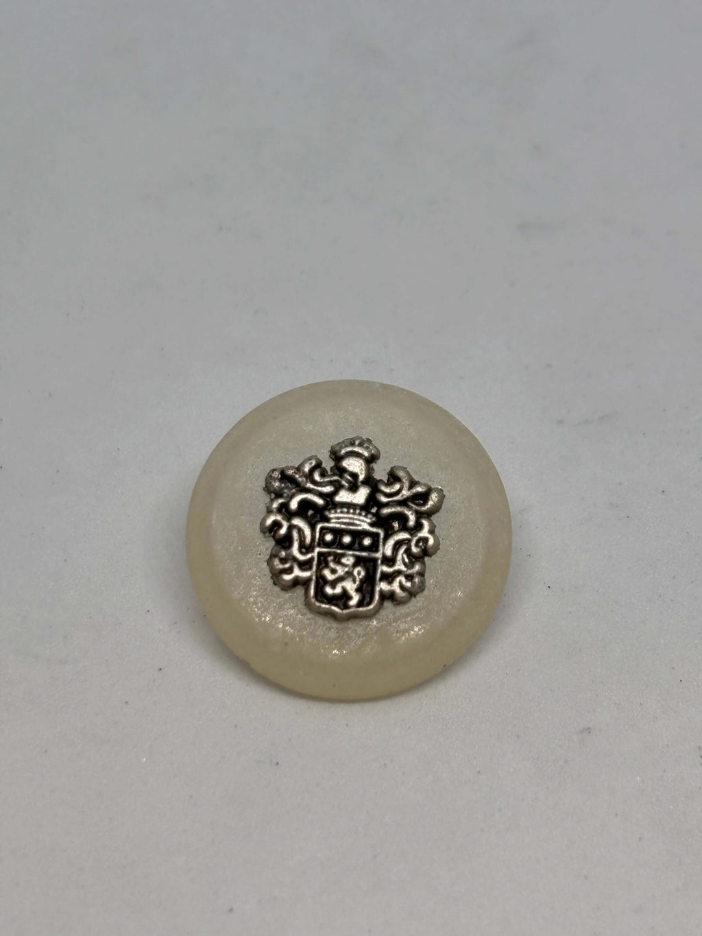 Botón 8400/F3 de vástago ecru 22mm con cresta heráldica, acabado blanco roto brillante, lujo vintage clásico. button