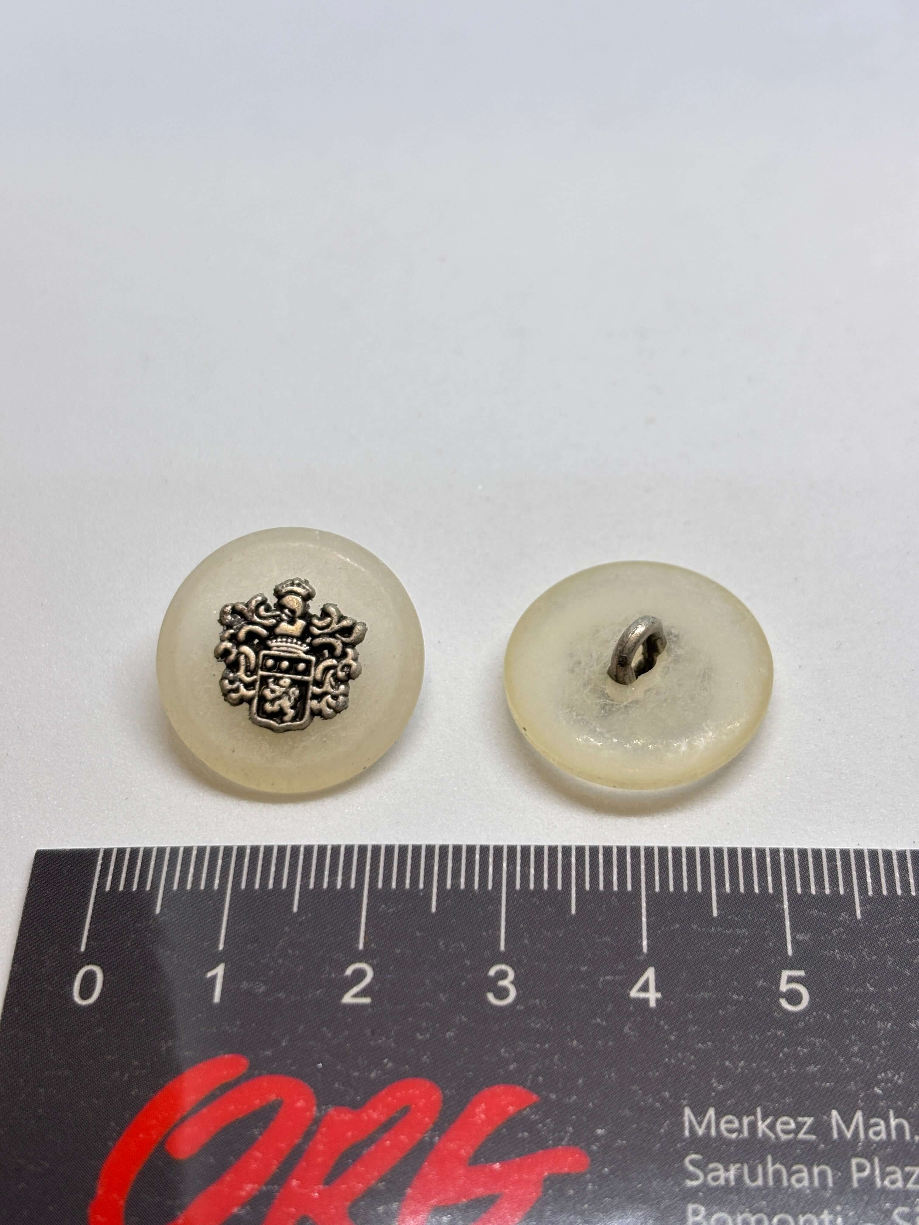 Botón 8400/F3 de vástago ecru 22mm con cresta heráldica, acabado blanco roto brillante, lujo vintage clásico. button