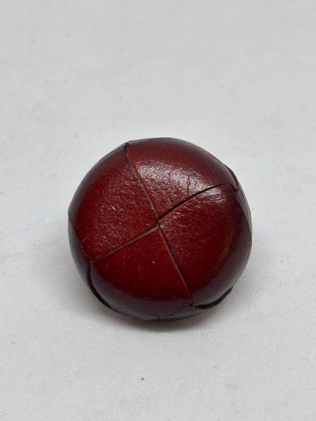 Botón B1 Burdeos de cuero auténtico, elegante y atemporal, diseño de cuatro paneles, textura suave y brillante. button