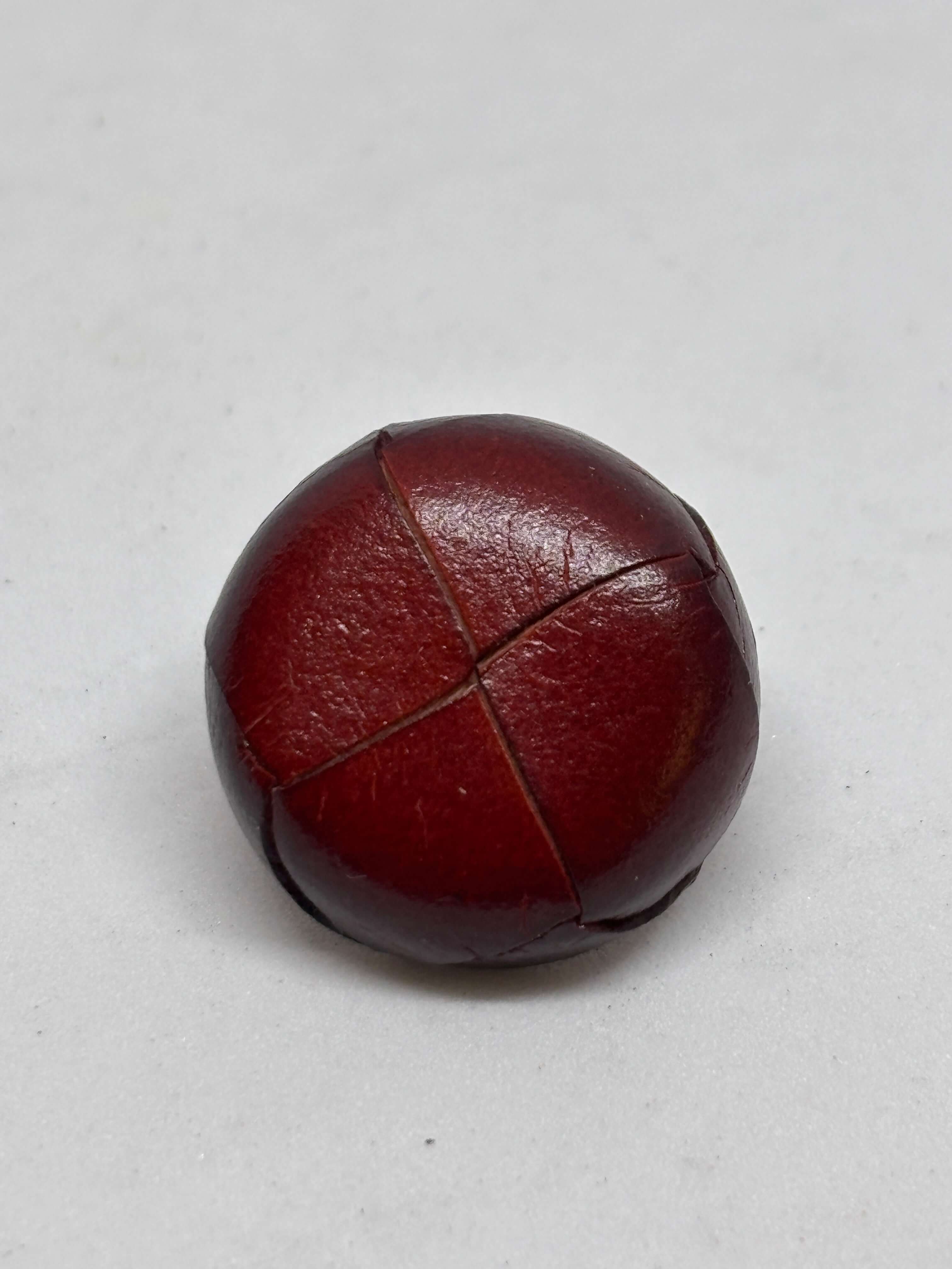 Botón B1 Burdeos de cuero auténtico, elegante y atemporal, diseño de cuatro paneles, textura suave y brillante. button