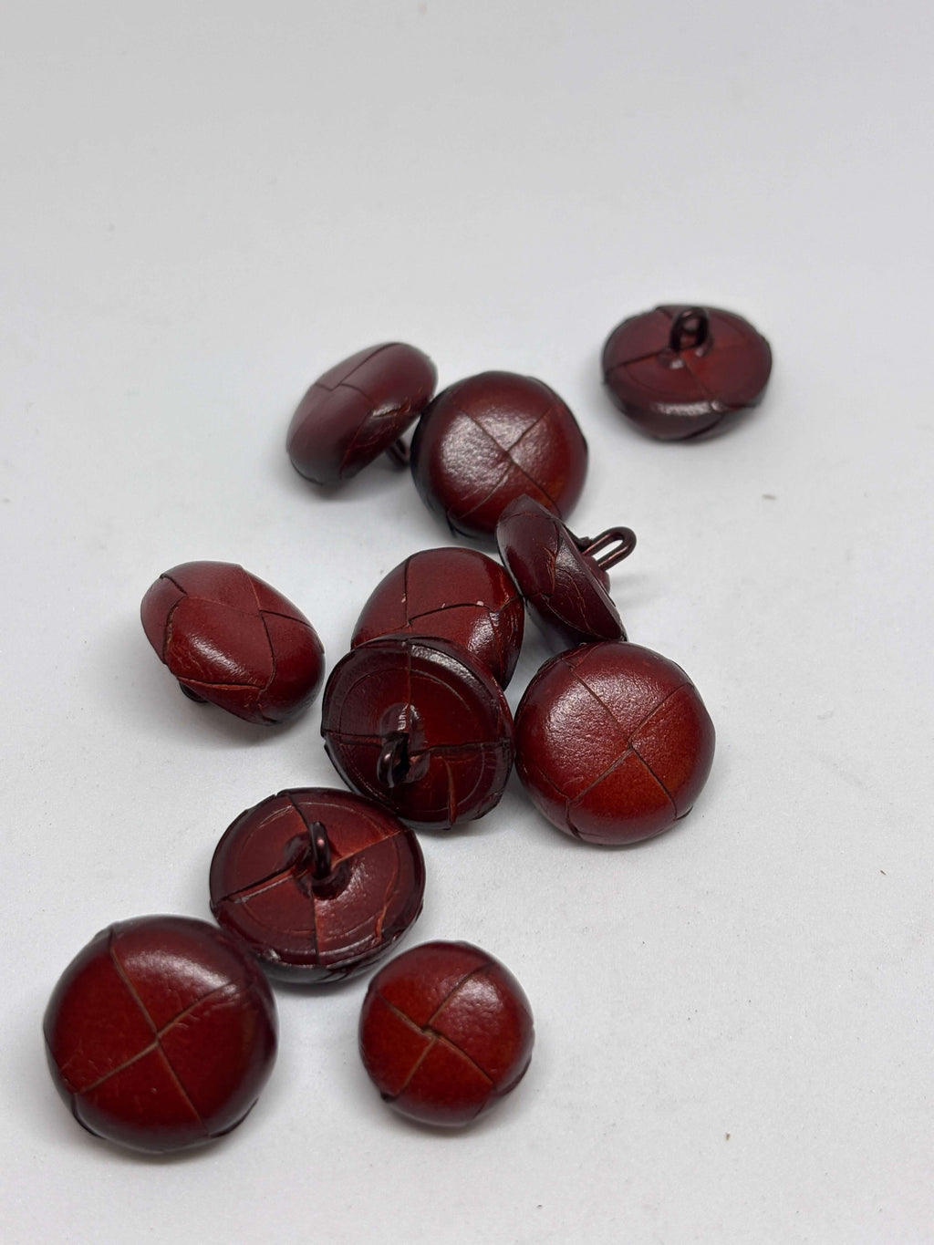 Botón B1 Burdeos de cuero auténtico, elegante y atemporal, diseño de cuatro paneles, textura suave y brillante. button