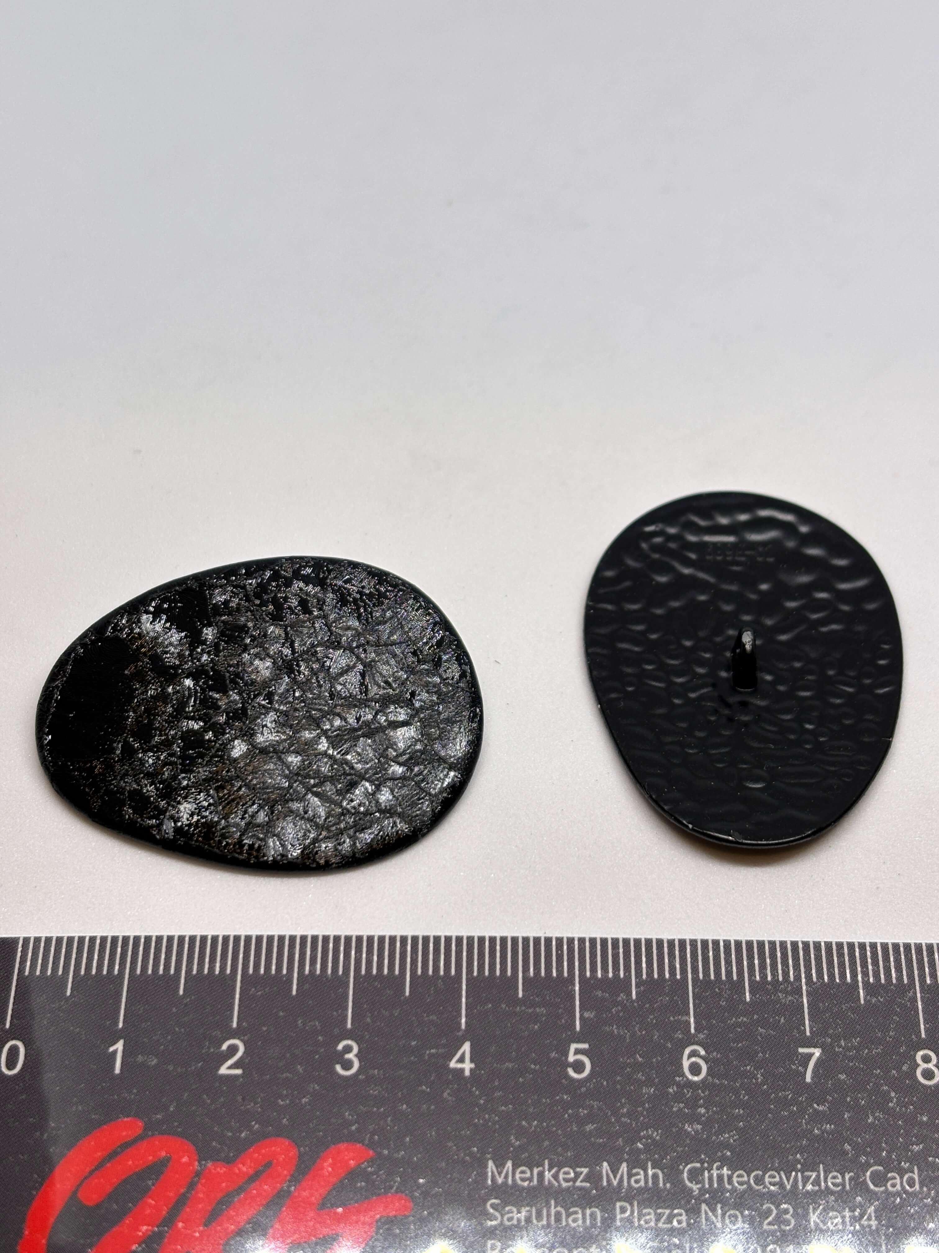 Botón B2233 de vástago negro oval texturizado imitando cuero envejecido, tamaño 38 mm. button