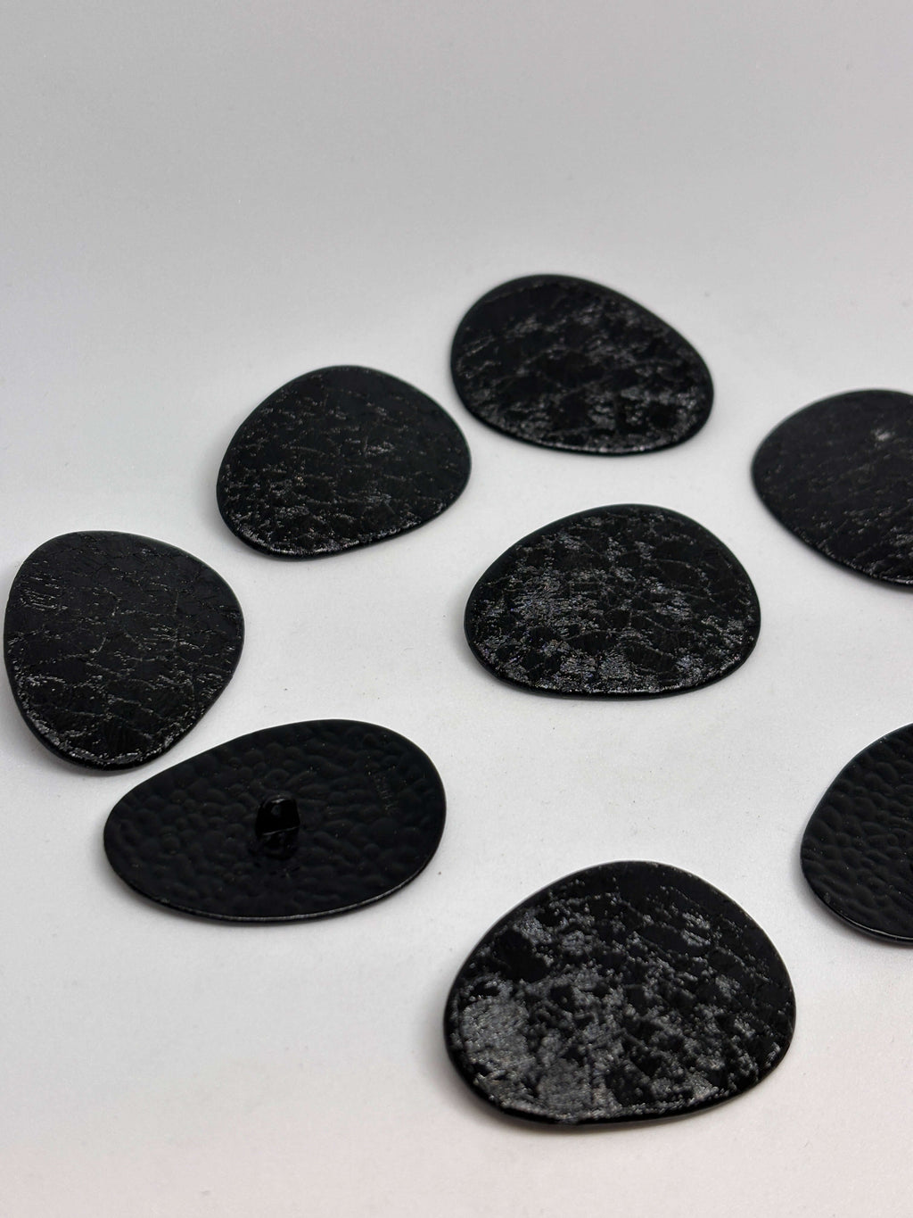 Botón B2233 de vástago negro oval texturizado imitando cuero envejecido, tamaño 38 mm. button