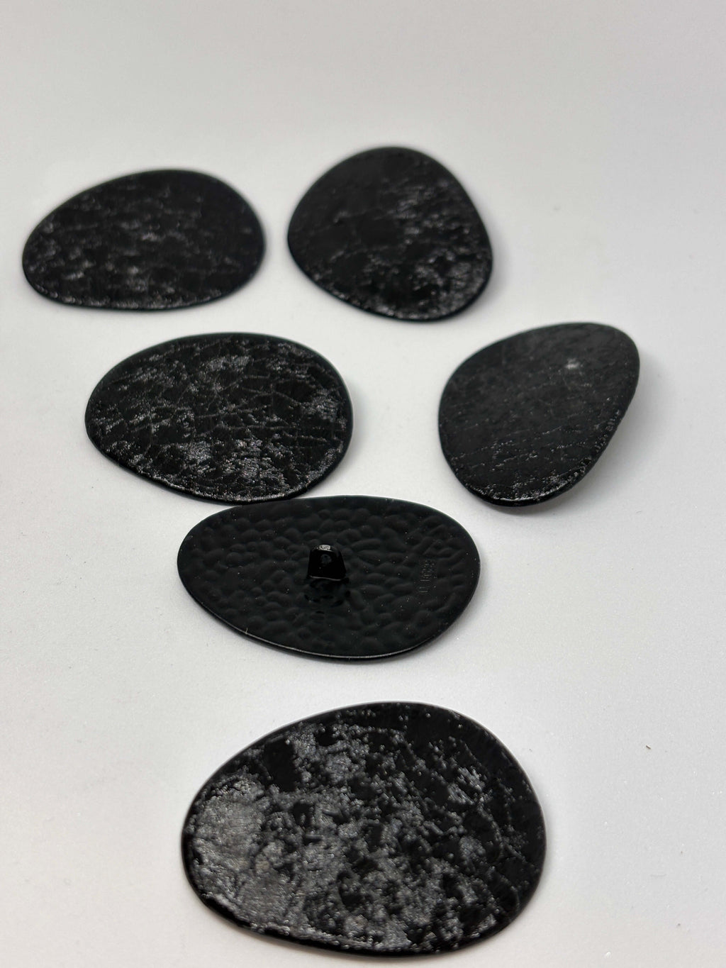 Botón B2233 de vástago negro oval texturizado imitando cuero envejecido, tamaño 38 mm. button