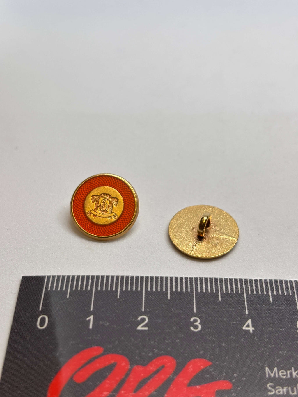 Botón B3672 de vástago oro de 15 mm con esmalte naranja y cresta heráldica en relieve. button