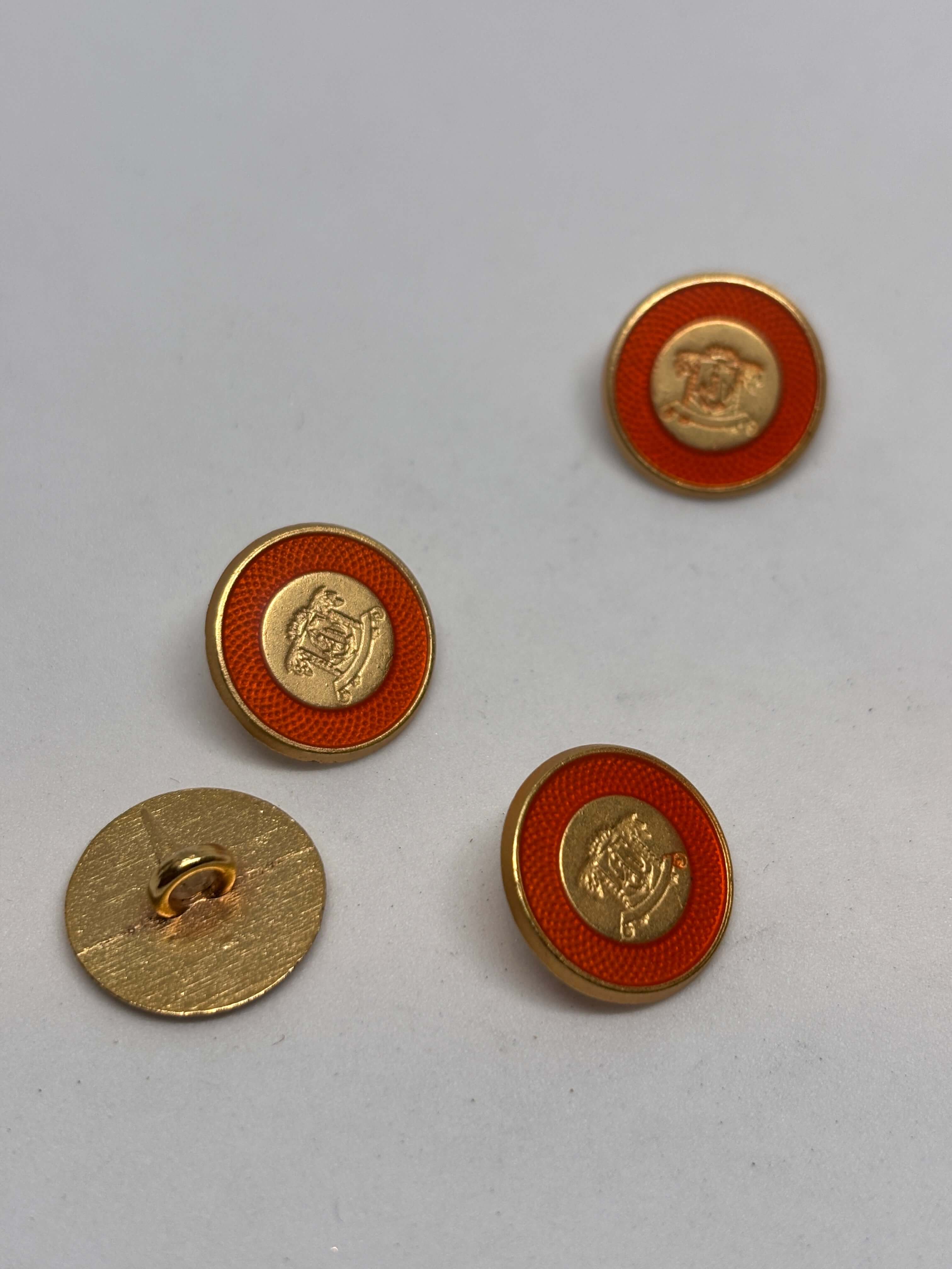 Botón B3672 de vástago oro de 15 mm con esmalte naranja y cresta heráldica en relieve. button