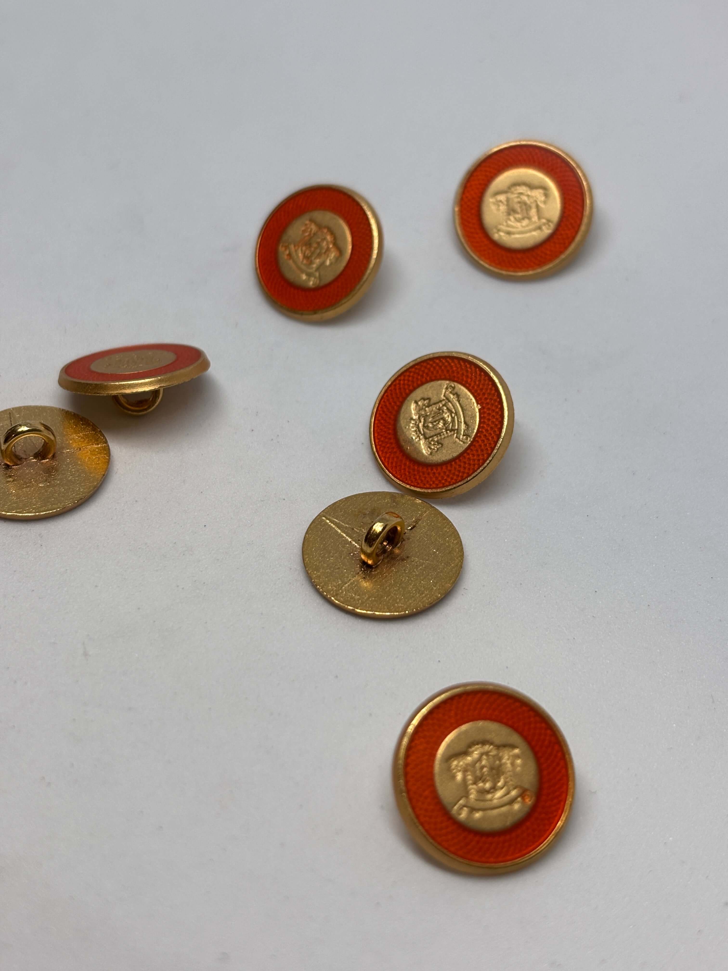 Botón B3672 de vástago oro de 15 mm con esmalte naranja y cresta heráldica en relieve. button