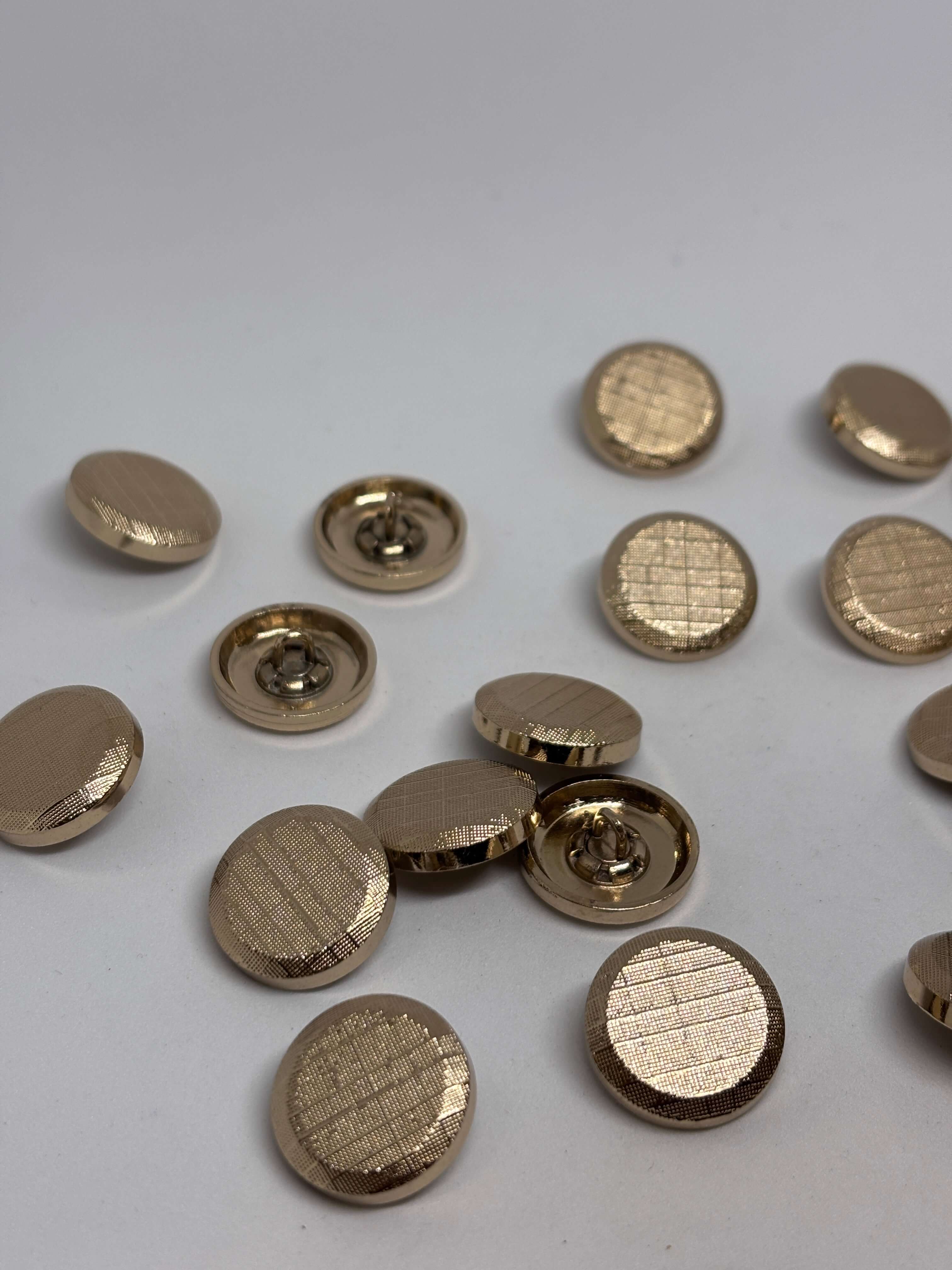 Botón B4177 de vástago oro 20mm con rejilla texturizada, acabado brillante, ideal para prendas con detalles elegantes. button
