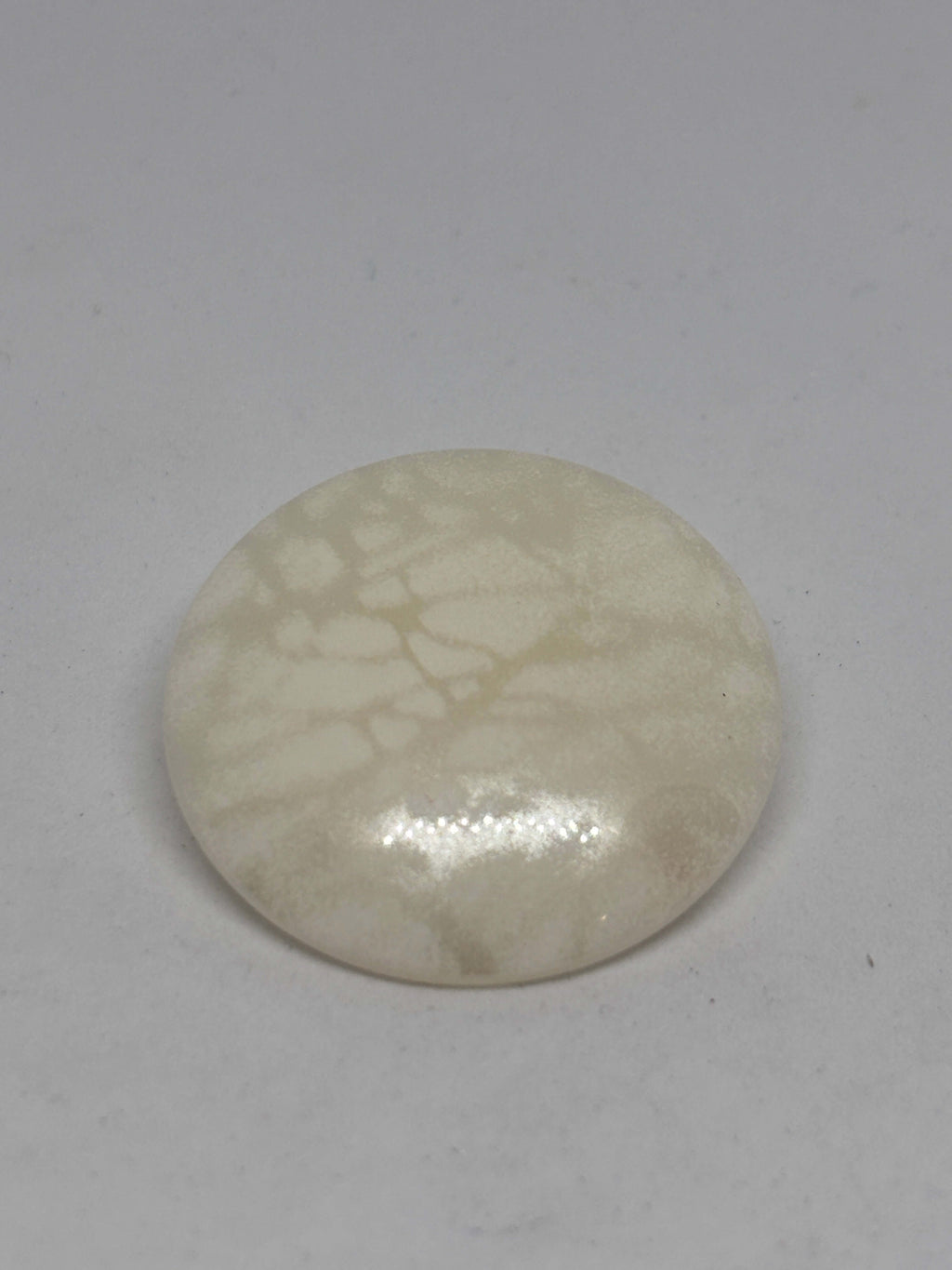 Botón B5979 de vástago de poliéster ecru 34mm con acabado brillante y veteado sutil tipo mármol. button