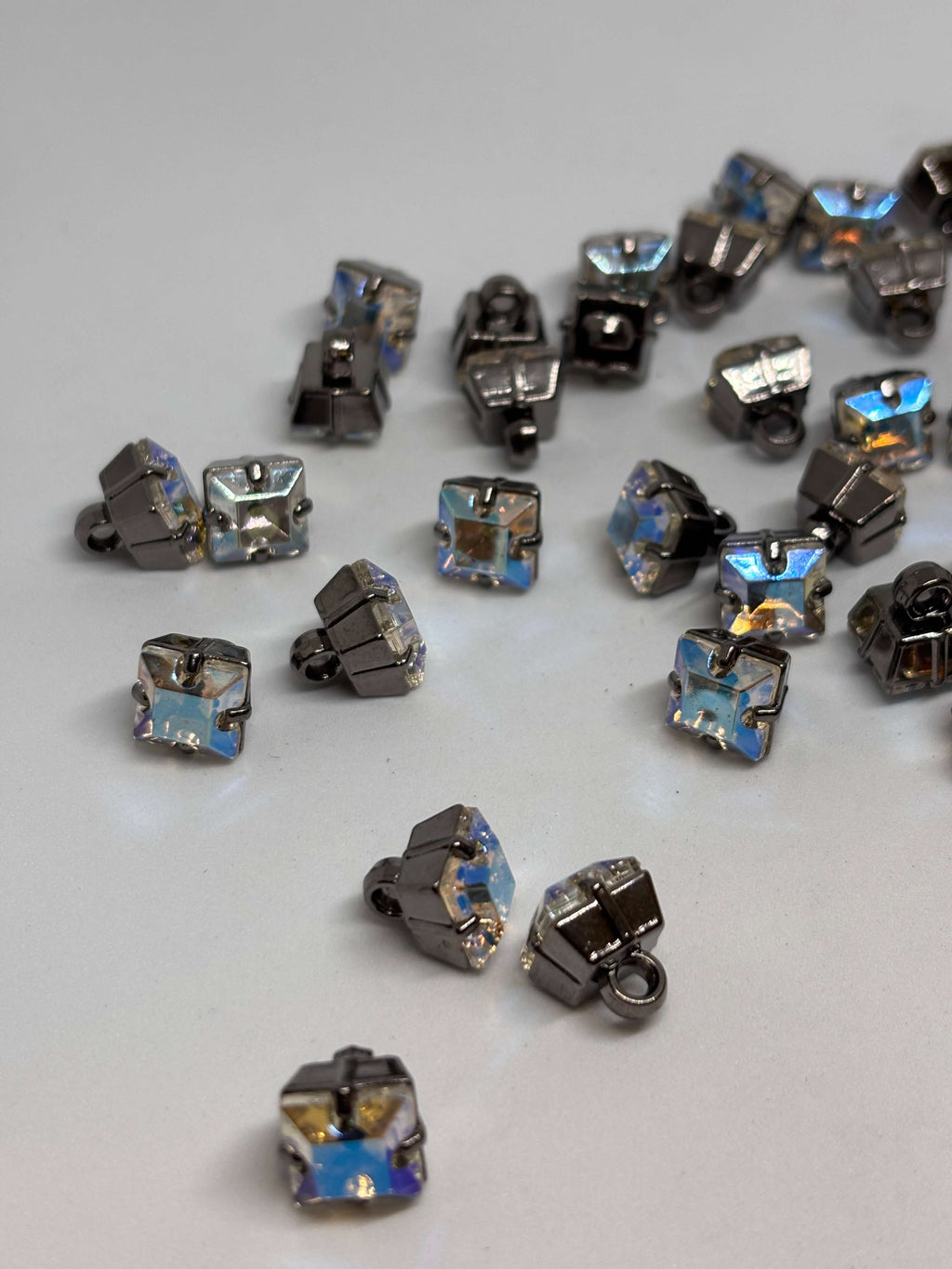 Botón cuadrado con acabado brillante en tonos azules y plateados, ideal para decoración elegante y sofisticada. button
