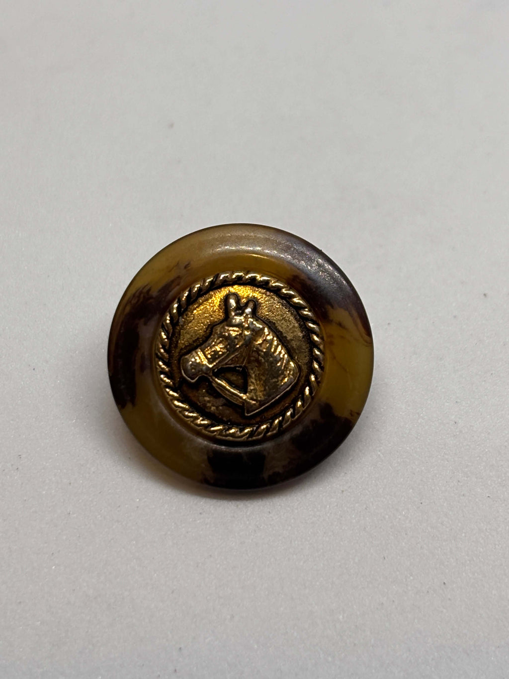 Botón PO27 de vástago oro 20mm con base efecto carey y diseño de cabeza de caballo en borde dorado. button