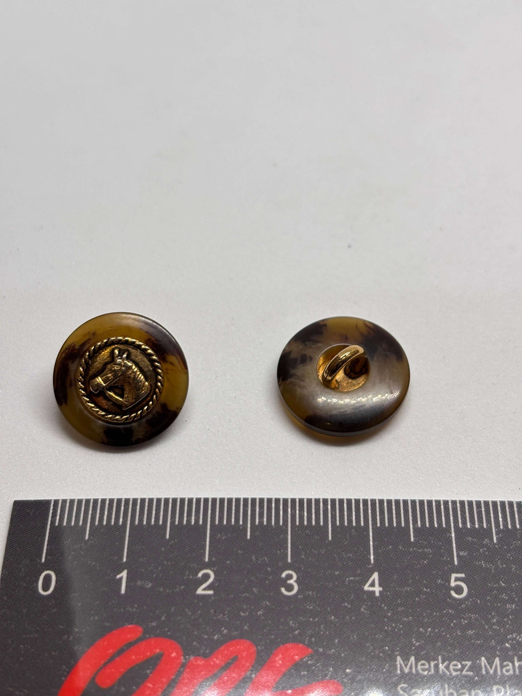 Botón PO27 de vástago oro 20mm con base efecto carey y diseño de cabeza de caballo en borde dorado. button