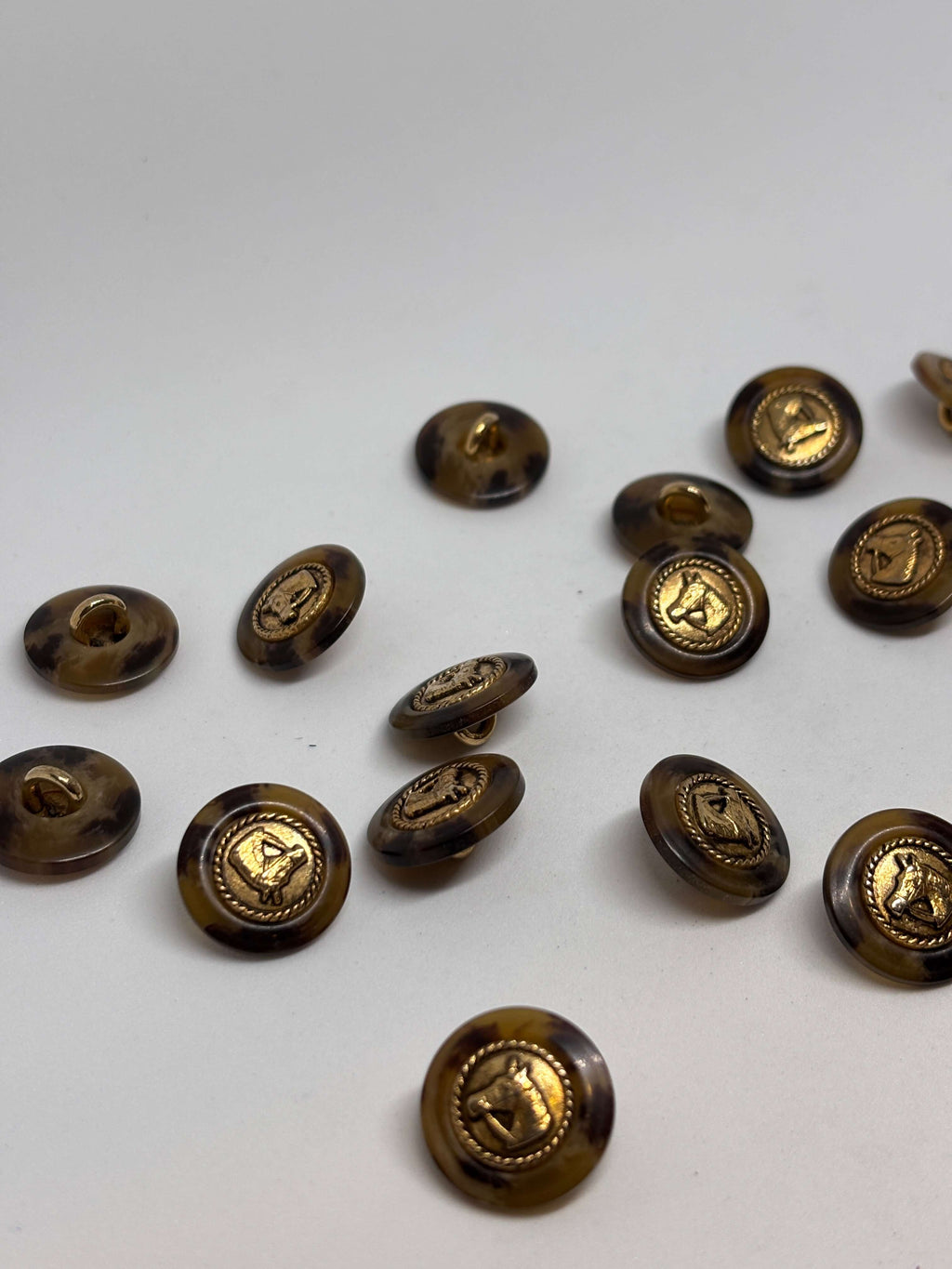 Botón PO27 de vástago oro 20mm con base efecto carey y diseño de cabeza de caballo en borde dorado. button