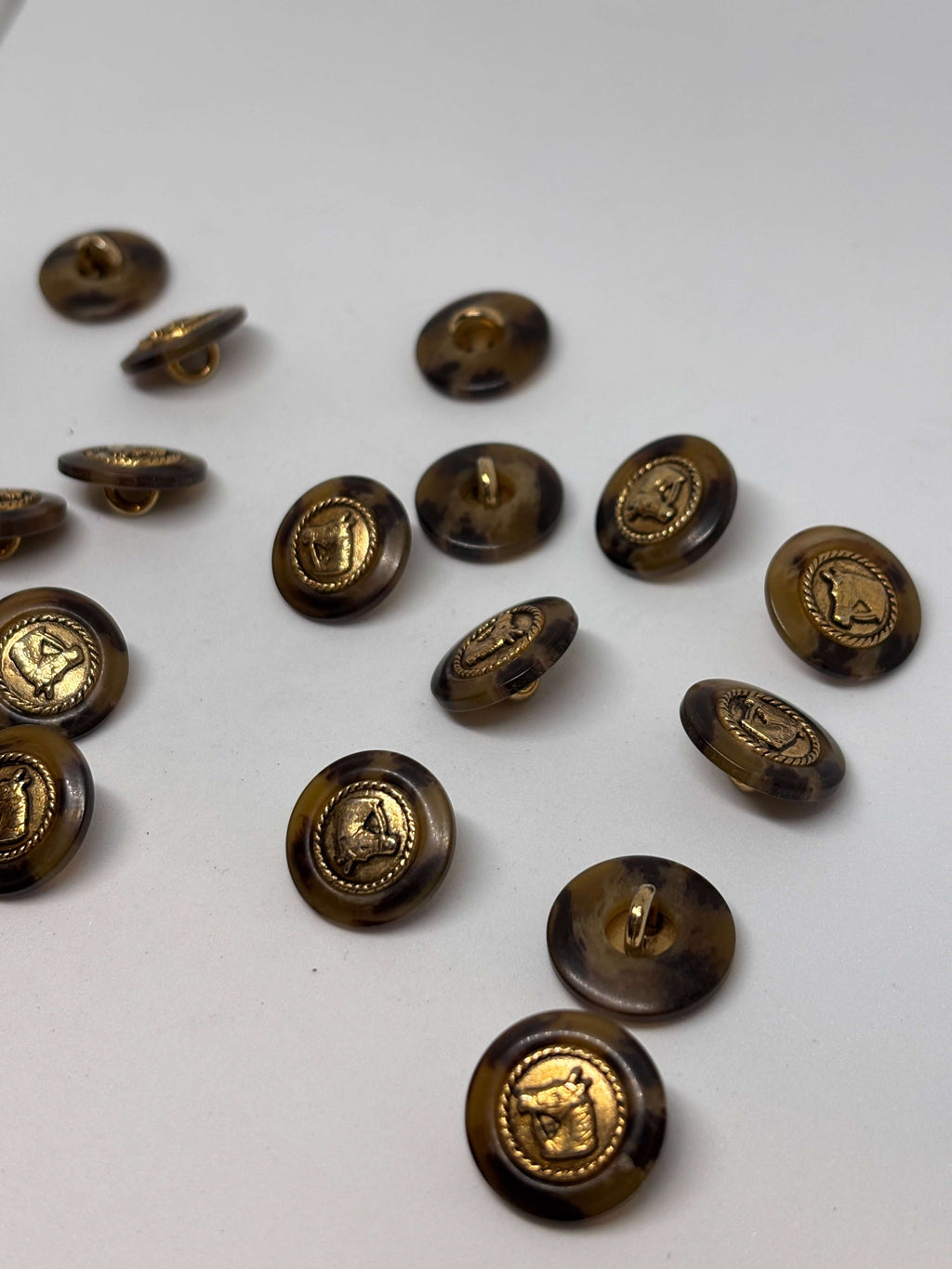 Botón PO27 de vástago oro 20mm con base efecto carey y diseño de cabeza de caballo en borde dorado. button