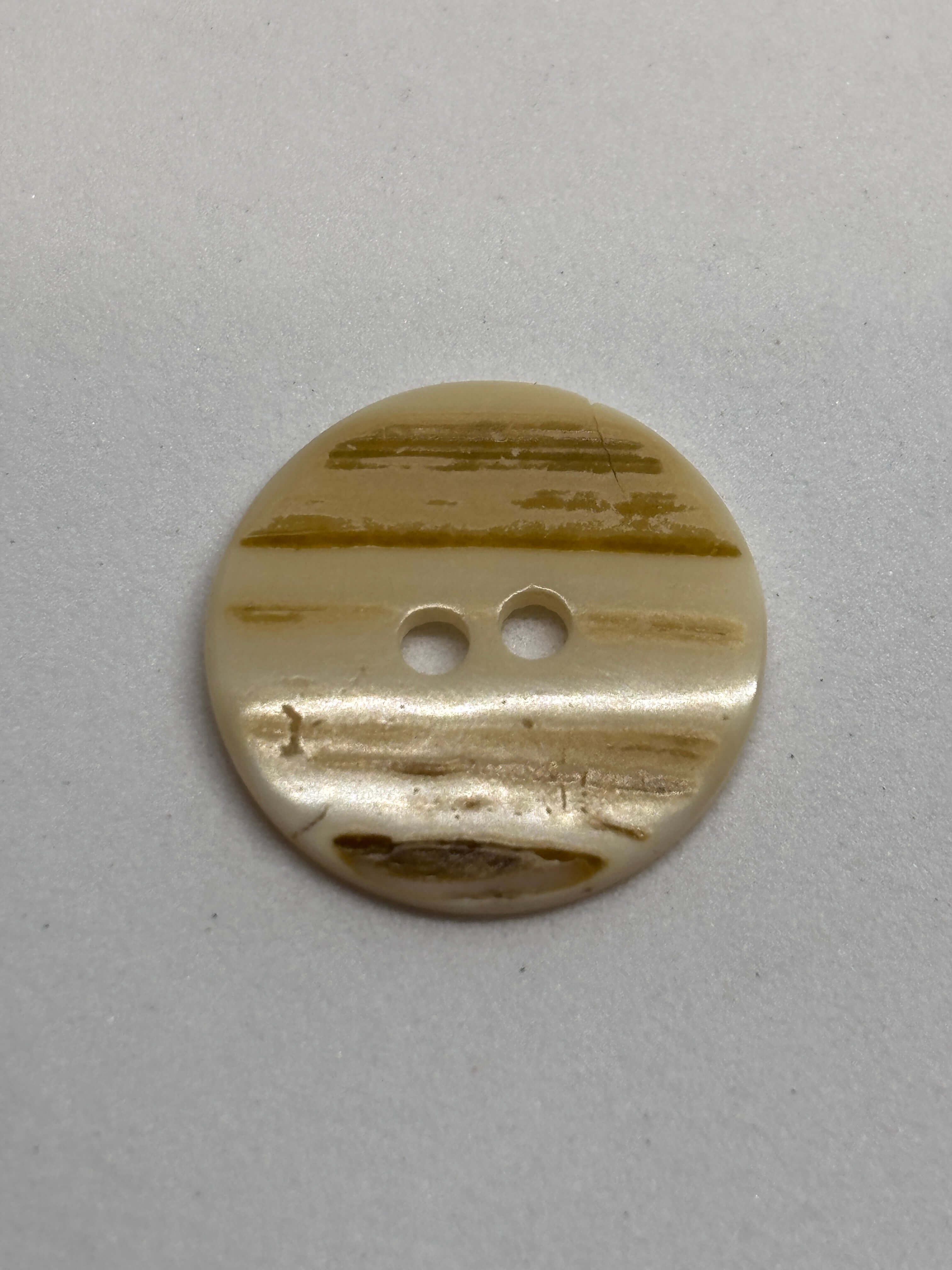 Botón T35/2H Nácar Natural 2 Agujeros 18mm en color marfil-crema con textura rayada y brillo perlado. button