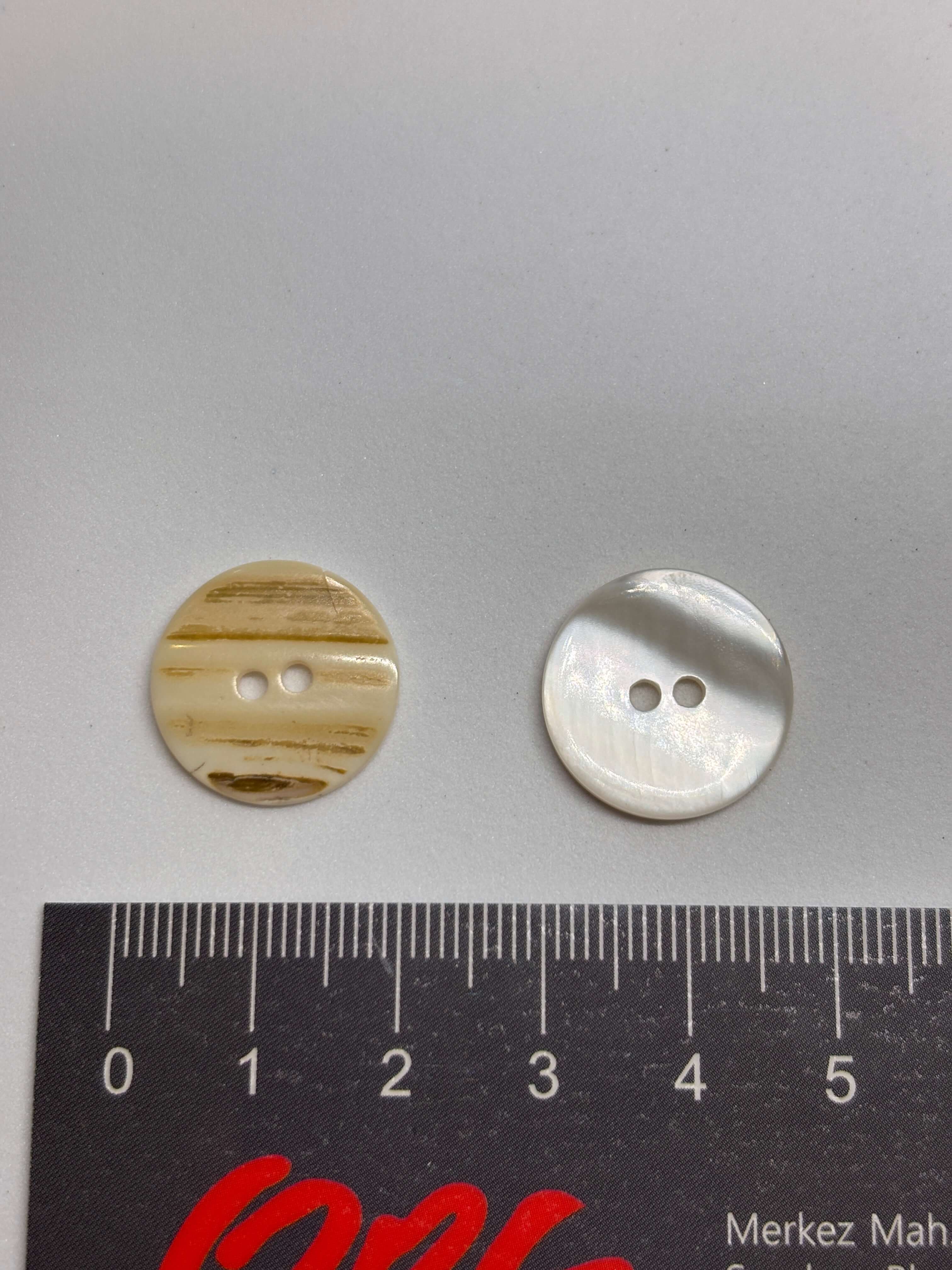 Botón T35/2H Nácar Natural 2 Agujeros 18mm en color marfil-crema con textura rayada y brillo perlado. button