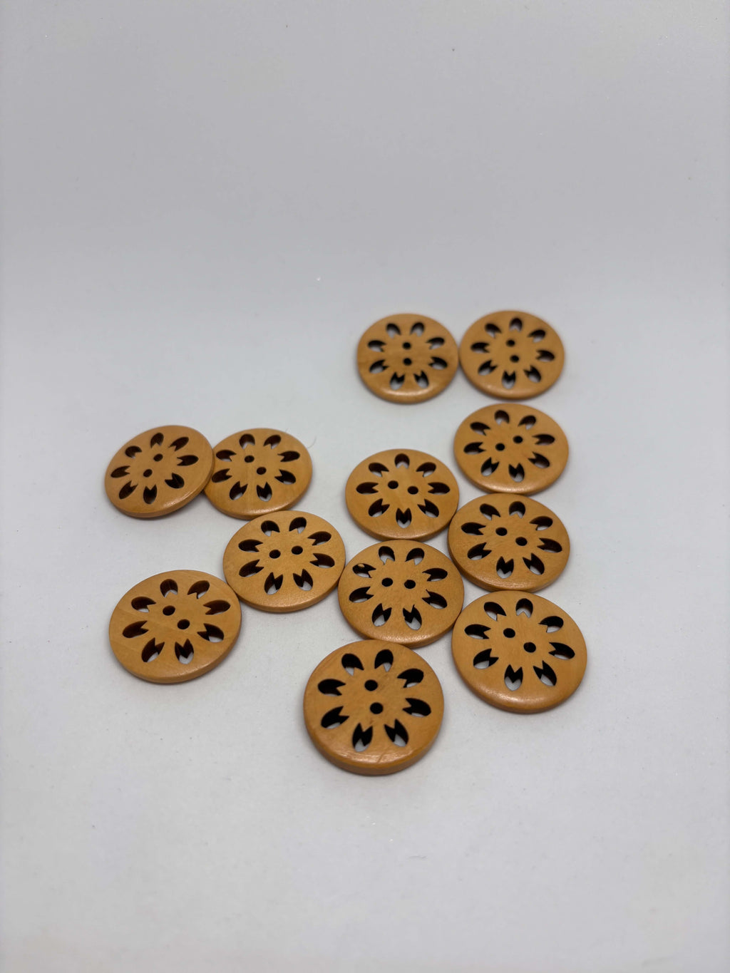 Botón WBB906 de madera natural, ovalado, 2 agujeros con diseño festoneado y rica veta, colores cálidos. button