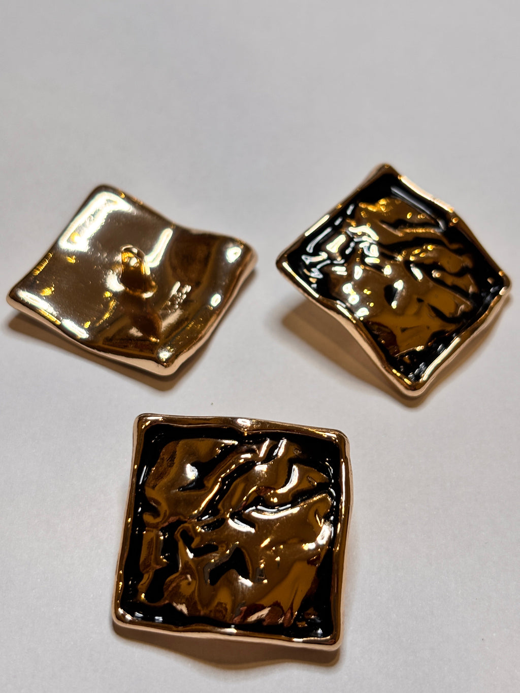 Shiny metal buttons in a square shape, showcasing a 32mm (50") shank button design. boton