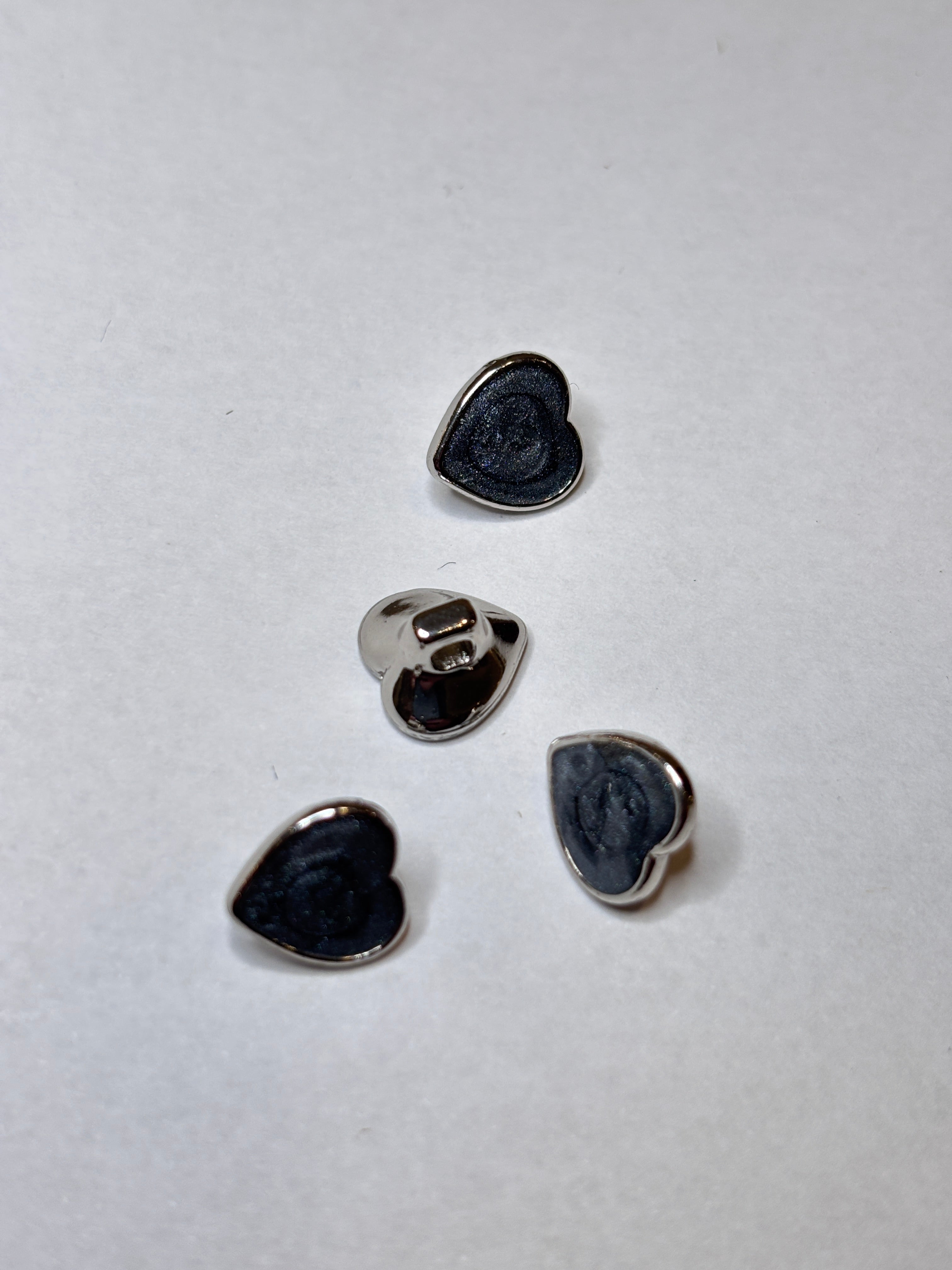 Heart-shaped metal buttons featuring a gold finish, perfect for sewing and craft projects, showcasing the elegance of a button. boton