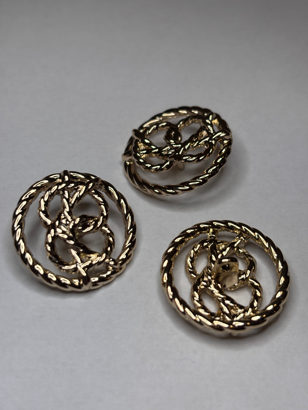 Button V123 - 15mm (24") - Shank button made of metal featuring a unique twisted design. boton