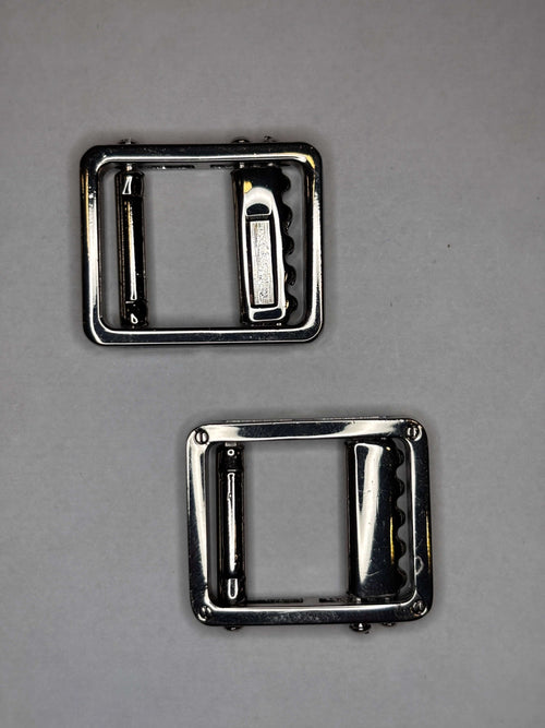 Belt buckle accessory in shiny metal finish, showcasing top and bottom views for stylish belt enhancements. Hebilla de cinturon