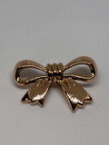 Decorative gold shank buttons shaped like bows, perfect for crafting and embellishing. botón