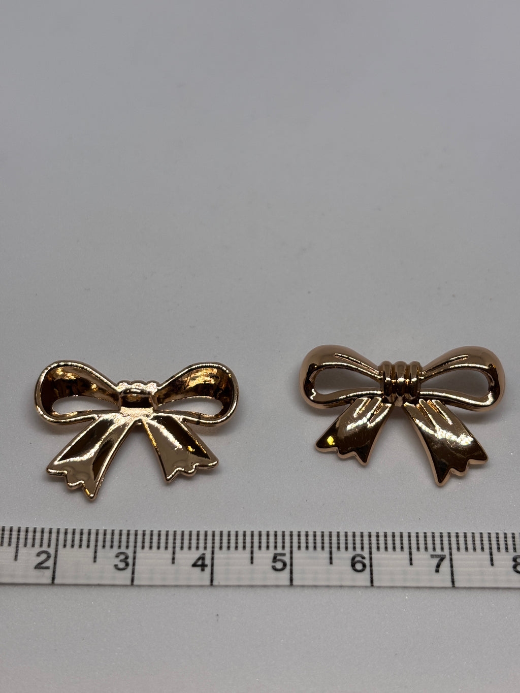 Decorative gold shank buttons shaped like bows, perfect for crafting and embellishing. boton