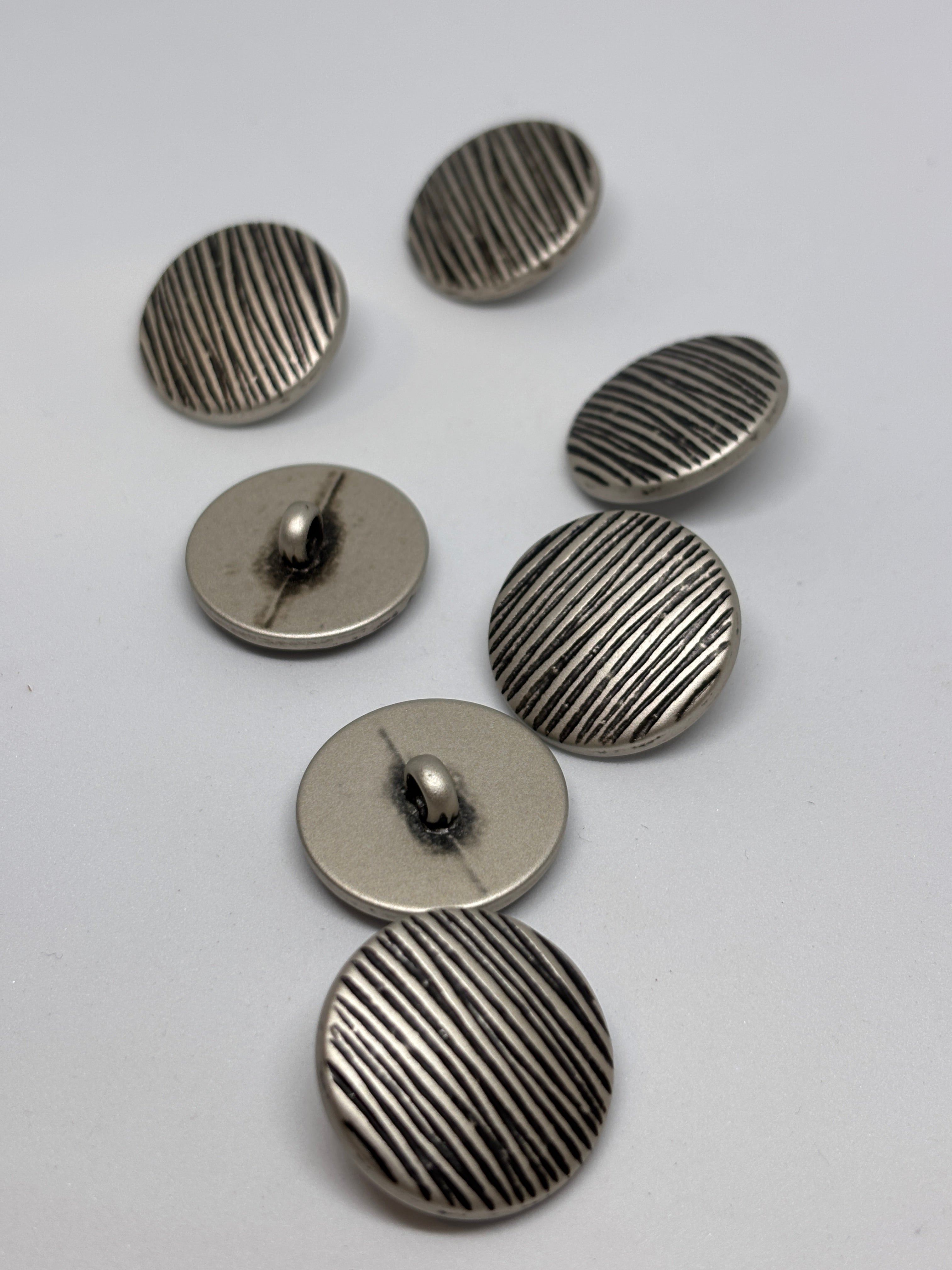 Button B7831 - 18mm (28"), 25mm (40") polyester shank button shown from both sides. boton