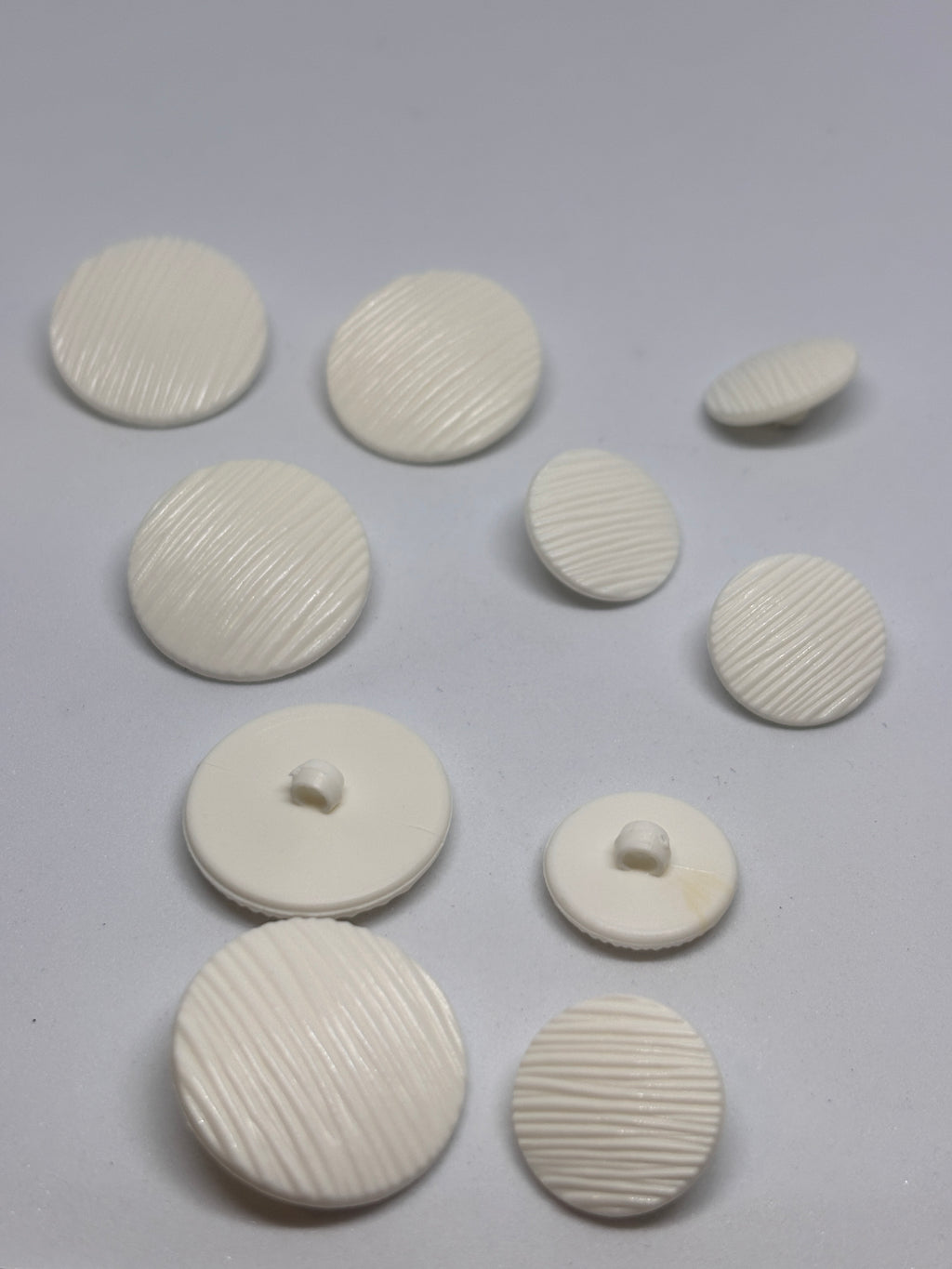 Button B7831 - 18mm (28"), 25mm (40") polyester shank button shown from both sides. boton