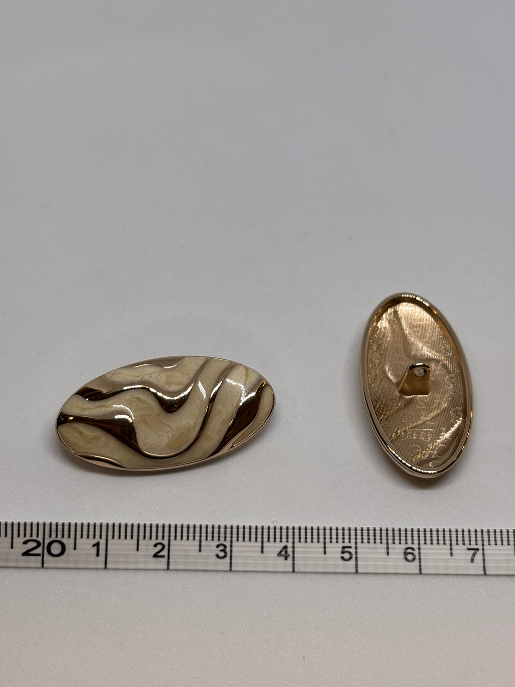 Button F959 - 38mm(60") - Shank button with metal body and wavy pattern, perfect for embellishing garments. boton