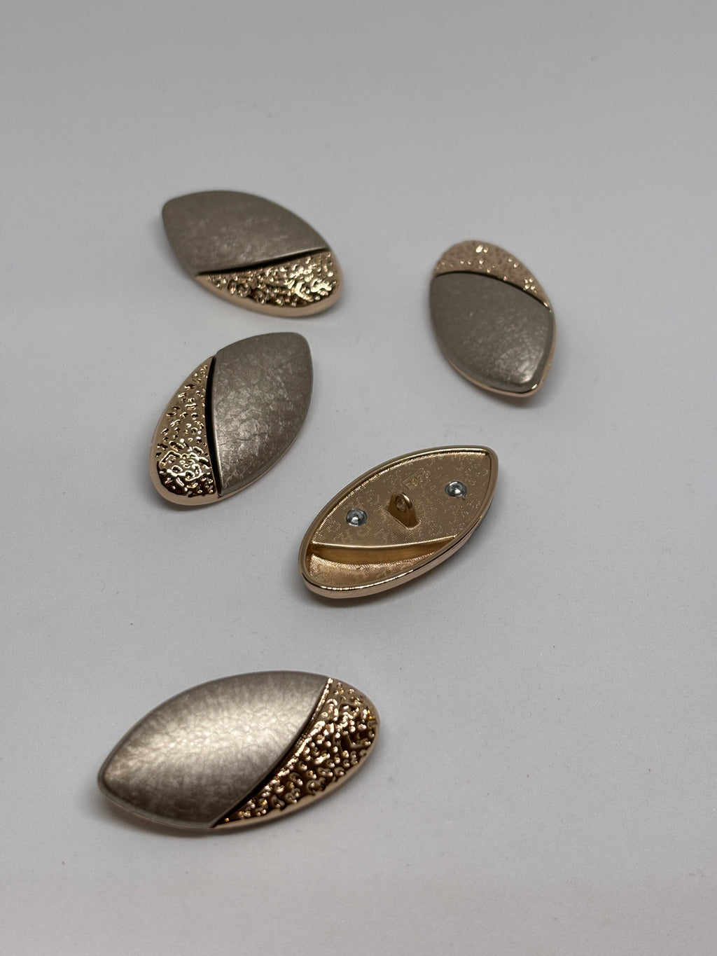 Button F958 - 38mm (60") Shank button showcased in metallic design, including decorative elements. boton