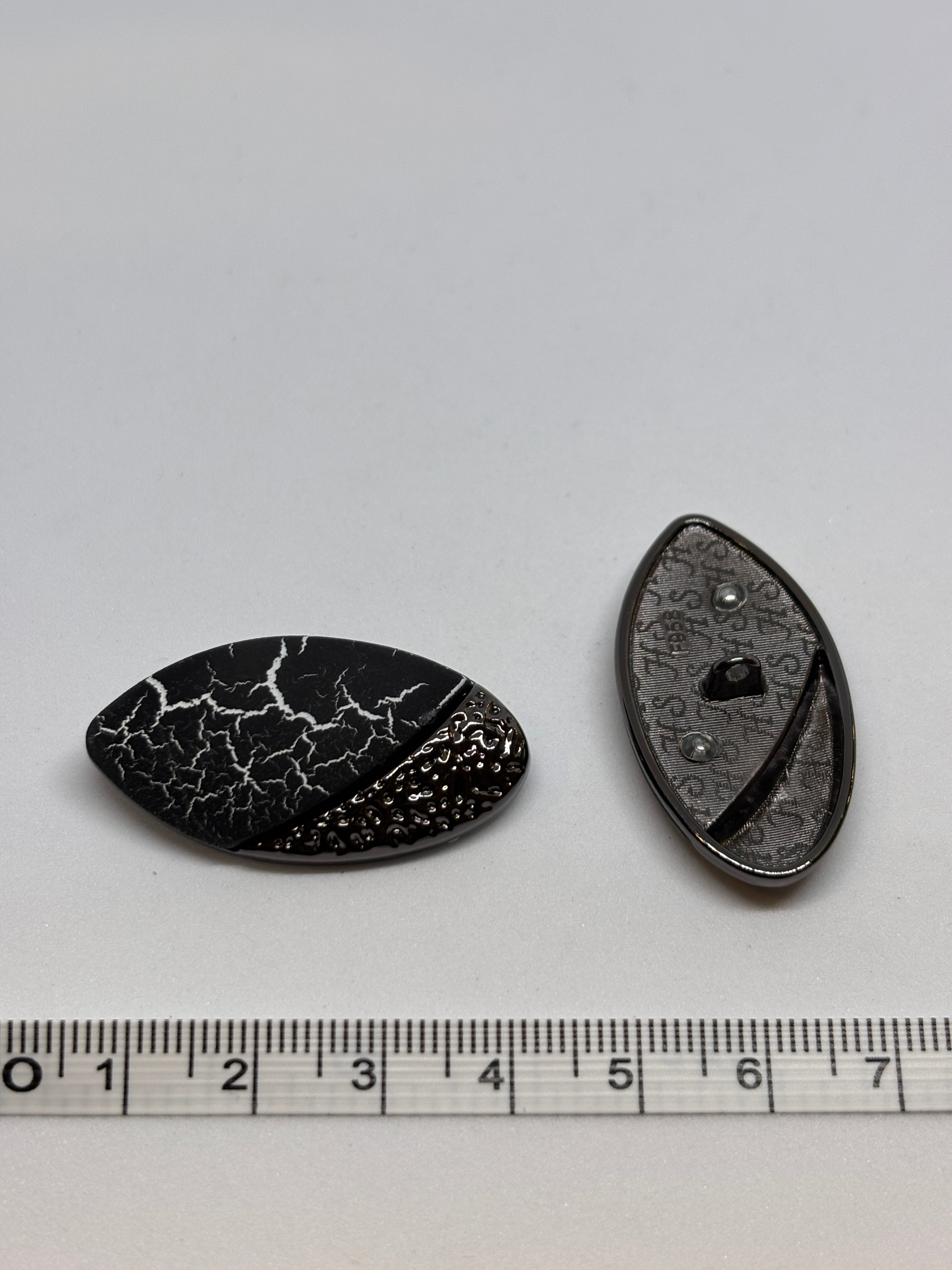 Button F958 - 38mm (60") Shank button showcased in metallic design, including decorative elements. boton