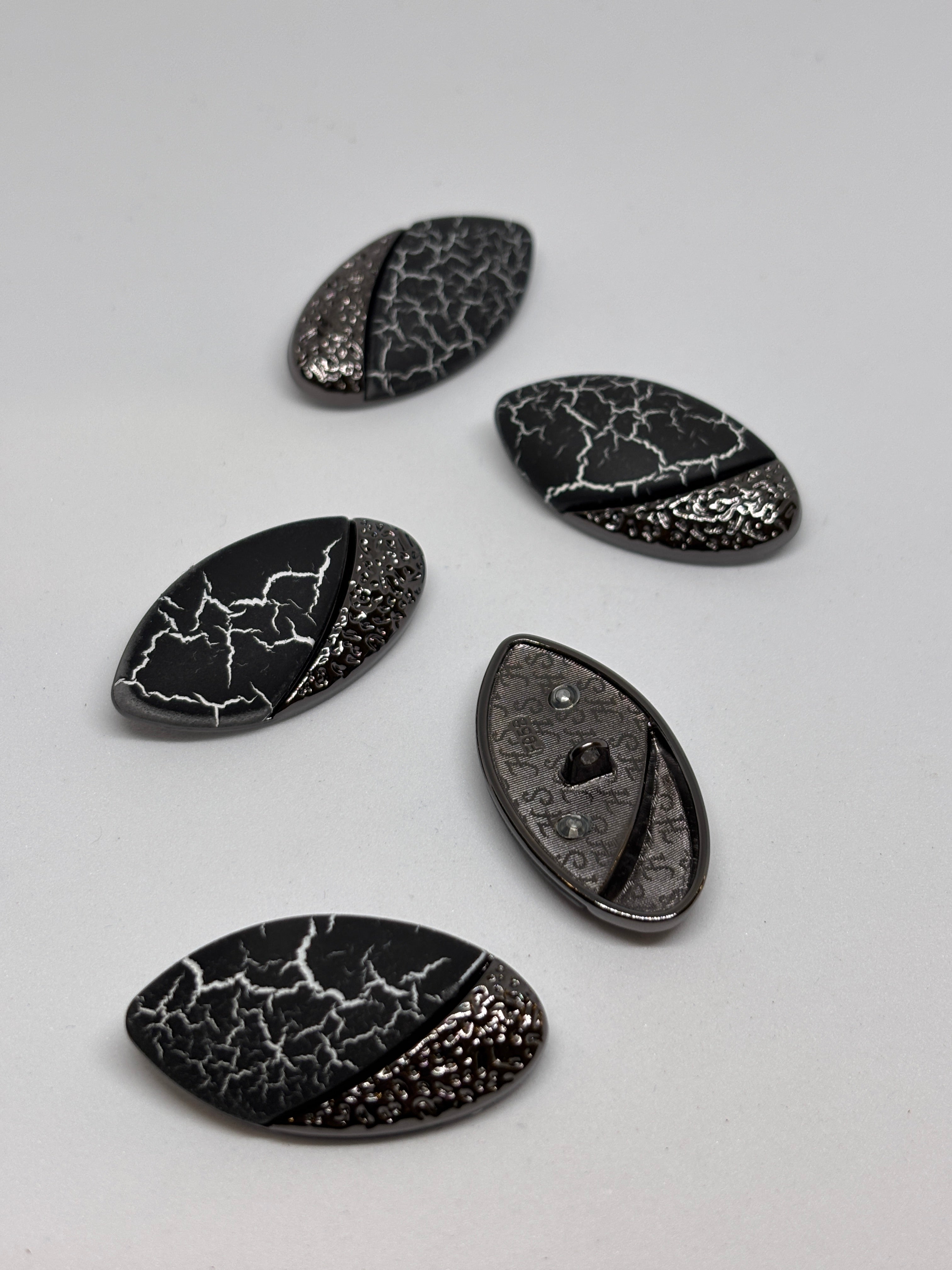 Button F958 - 38mm (60") Shank button showcased in metallic design, including decorative elements. boton