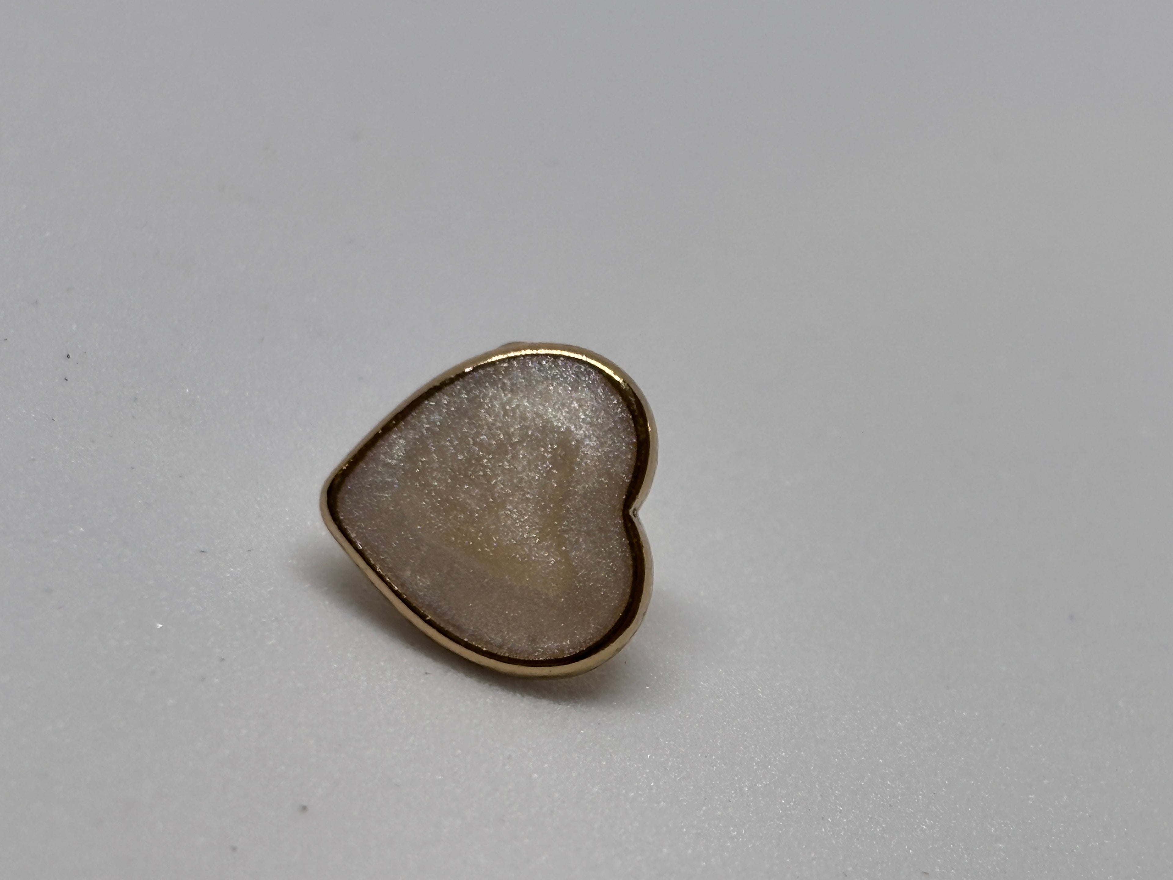 Heart-shaped metal buttons featuring a gold finish, perfect for sewing and craft projects, showcasing the elegance of a button. boton