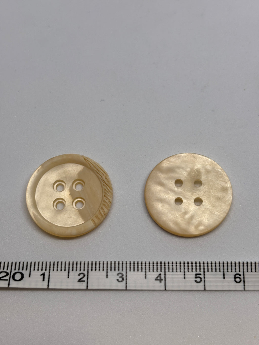 Polyester button P54299 - 36" in off-white color, featuring four holes for sewing and crafting. Boton