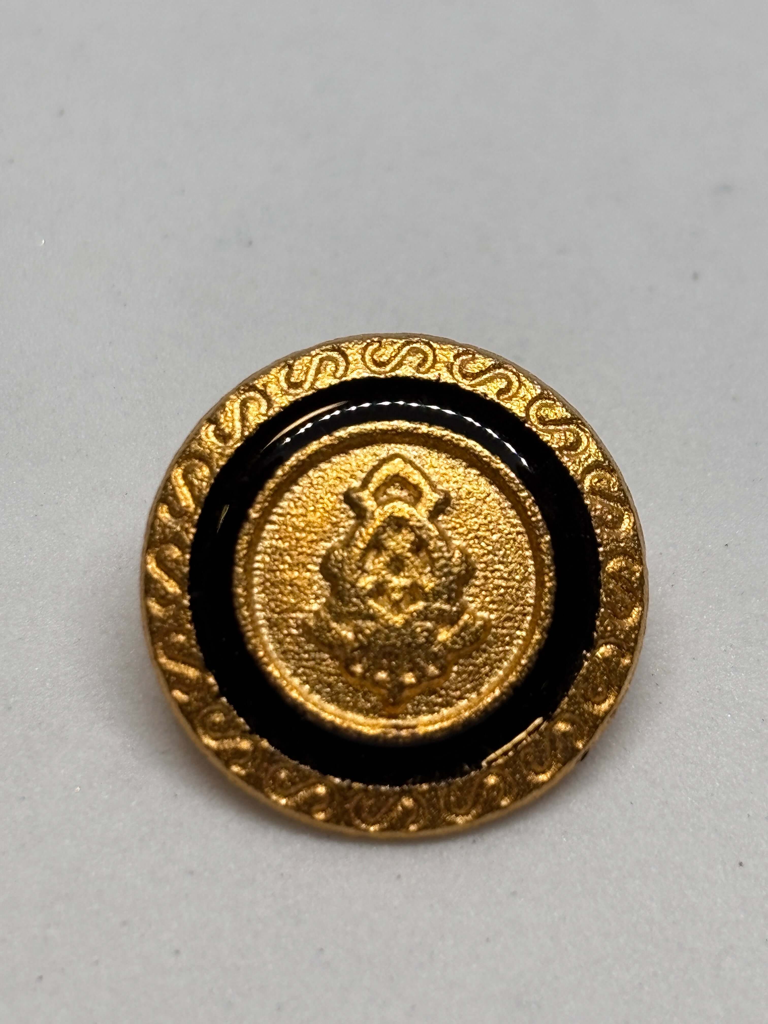 Botón Z881 de vástago en oro con centro de esmalte negro y emblema de cresta heráldica, tamaño 20mm. button